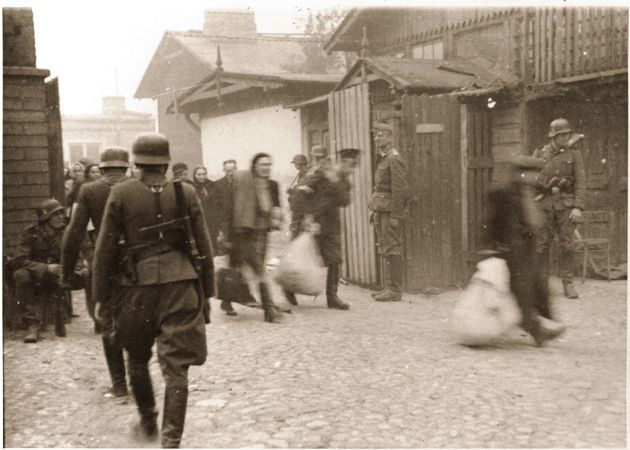 Jewish laborers are forced by SS troops to evacuate a Warsaw ghetto factory